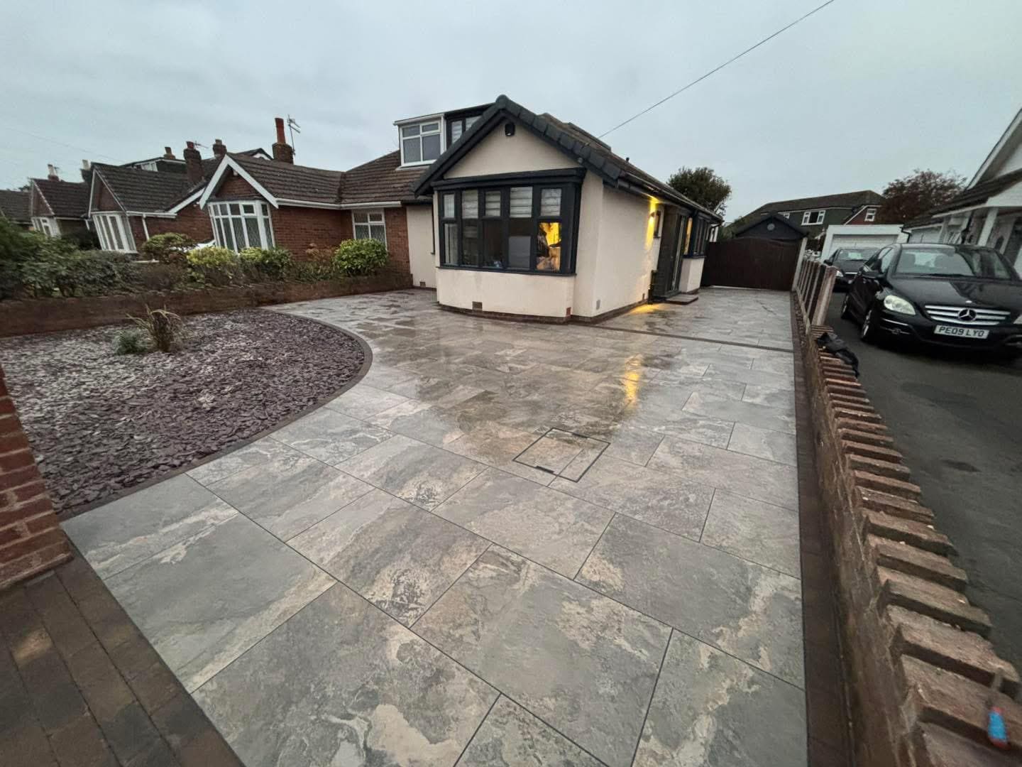 Porcelain paving driveway with decorative stone feature at bungalow